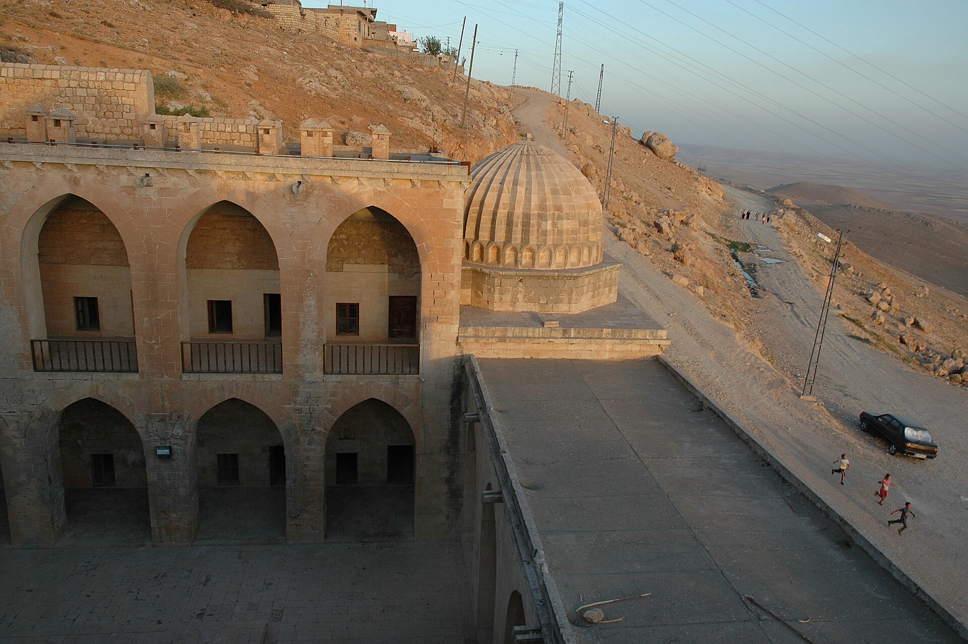 Kasımiye Medresesi'nin revaklı avlusu, dilimli kubbe ve arkada Mardin yamacı